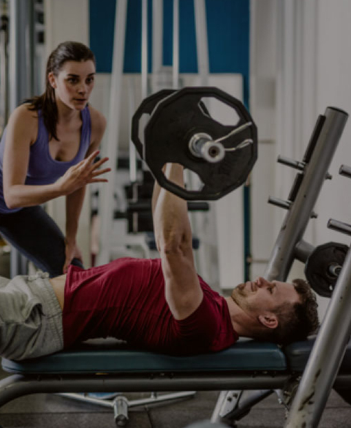 Trainer coaching man on weight lifting workout.